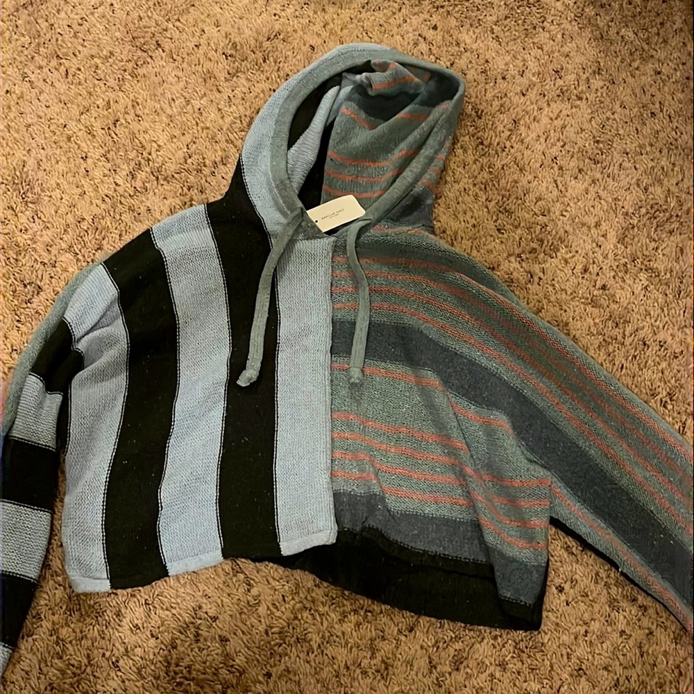 a baggy cropped sweater with light blue,dark grey,blush,and darker blue stripes